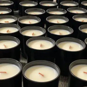 several wood wick candles in black tins