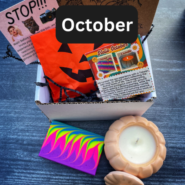 a box with a jack o lantern, a colorful bar of soap, and a pumpkin shaped candle